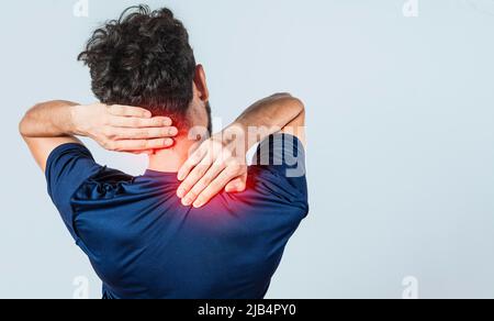 Nahaufnahme der Person mit Schulter- und Nackenproblemen, wund Mann berührt seine Schulter auf isoliertem Hintergrund, Lendenwirbelsäule und muskuläre Probleme Konzept Stockfoto