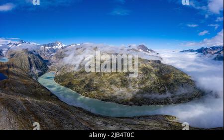 Luftaufnahme der Grimselregion mit den 3 Stauseen, Grimselsee, Triebtenseewli- und Oberaarsee und mit dem Nebelmeer über dem Stockfoto