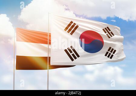 Sonniger blauer Himmel und Flaggen von Südkorea und jemen Stockfoto