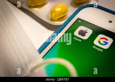 Kumamoto, Japan - Mai 7 2020 : Konzeptbild des Apple & Google-Logos auf dem iPhone-Bildschirm mit Pillen und Gesichtsmaske auf weißem Hintergrund. Stockfoto