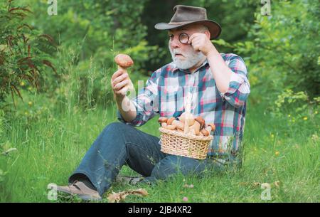 Großvater mit Korb von Pilzen und einem überraschenden Gesichtsausdruck. Stockfoto