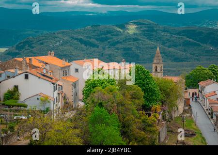 Panoramablick vom Hügel der Stadt Motovun mit Blick auf den Fluss Mirna an einem bewölkten sčring-Tag. Rote Dächer und Kirche im Vordergrund. Stockfoto