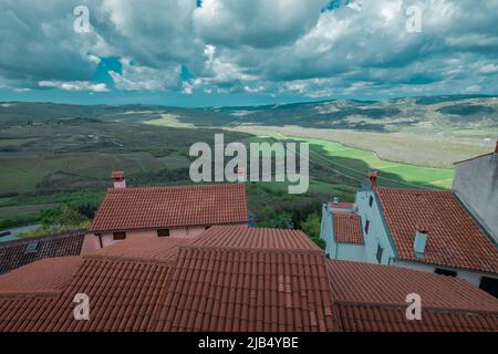 Panoramablick vom Hügel der Stadt Motovun mit Blick auf den Fluss Mirna an einem bewölkten sčring-Tag. Rote Dächer im Vordergrund. Stockfoto