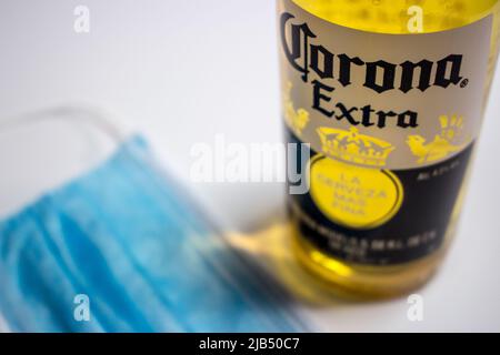 Kumamoto, Japan - Mai 7 2020: Corona Extra Bier mit blauer Gesichtsmaske auf weißem Hintergrund (Konzeptbild). Stockfoto
