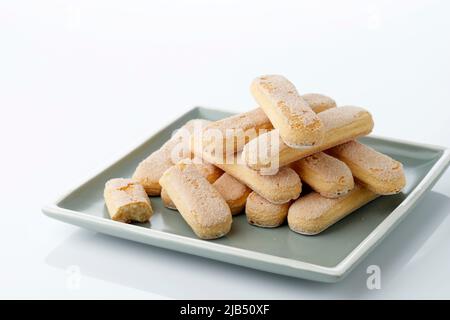 Gestapeltes Italienisches Plätzchen Savoiardi. Süße Kekse auf dem Teller. Biskuitplätzchen für Tiramisu Stockfoto