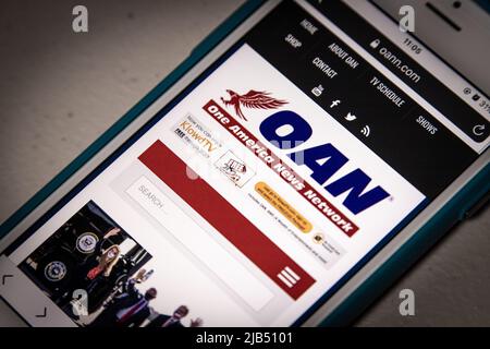 Website von One America News Network (OANN), einem rechtsextremen Pro-Donald Trump-Kabelkanal von Herring Networks, Inc., auf dem iPhone in dunkler Stimmung Stockfoto