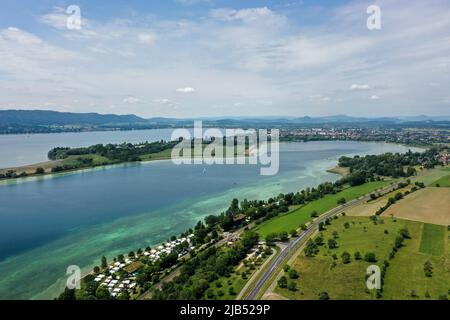 Gaienhofen Am Bodensee, Deutschland. 30.. Mai 2022. Dutzende Wohnwagen stehen am Rande des Bodensees auf dem Campingplatz Willam bei Radolfzell. Im Hintergrund sind die Halbinseln Mettnau und Höri am Bodensee zu sehen. (Foto aufgenommen mit Drohne; zu 'Land will den Weg frei machen für erste Windturbinen am Bodensee') Quelle: Felix Kästle/dpa/Alamy Live News Stockfoto