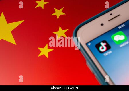 Konzeptbild der Apps TikTok und WeChat auf dem iPhone auf chinesischer Flagge. Aufgrund nationaler Sicherheitsbedenken werden TikTok und WeChat in den USA verboten Stockfoto