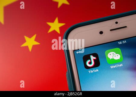 Konzeptbild der Apps TikTok und WeChat auf dem iPhone auf chinesischer Flagge. Aufgrund nationaler Sicherheitsbedenken werden TikTok und WeChat in den USA verboten Stockfoto