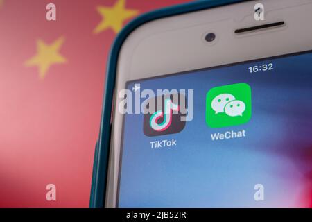 Konzeptbild der Apps TikTok und WeChat auf dem iPhone auf chinesischer Flagge. Aufgrund nationaler Sicherheitsbedenken werden TikTok und WeChat in den USA verboten Stockfoto