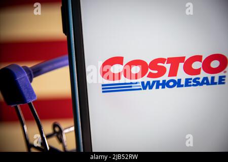 Logo von Costco, einem US-amerikanischen multinationalen Konzern, betreibt eine Kette von nur Mitgliedschaftsclubs auf dem iPhone im Warenkorb mit US-Flagge. Stockfoto