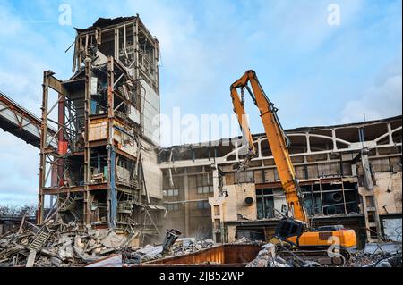 Demontage des alten Industriegebäudes durch Hochbagger Stockfoto