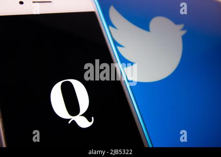 Kumamoto / JAPAN - Okt 20 2020 : das Logo von Qanon, einer rechtsextremen Verschwörungsgruppe, auf dem iPhone mit Twitter-Logo als Hintergrund. Stockfoto