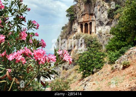 Lykische Gräber in der türkischen Stadt Fethiye. Die Gräber von Amintas, die in den Felsen geschnitzt wurden, erheben sich über der Stadt und in der Ferne ein Panorama der Stadt Stockfoto