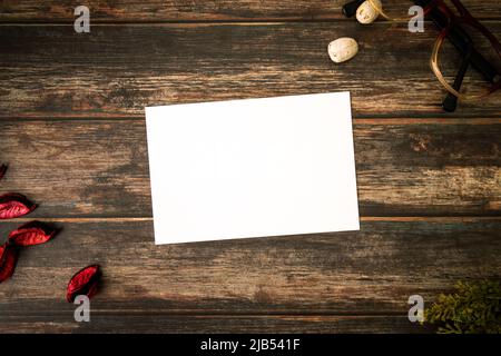 Feminines Desktop-Mockup mit leerer weißer Papierkarte, Vintage-Brillen, Ästen und Pot Pourri auf braunem Shabby-Tisch. Stilvolles Retro-Konzept Stockfoto