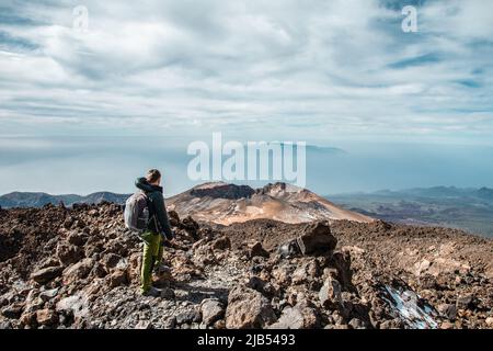 Junger Mann auf dem Gipfel des Vulkans El Teide auf Teneriffa oder Berg mit Blick ins Tal mit herrlicher Aussicht. Bewerter des Vulkans Pico Viejo Stockfoto