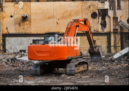 Hydraulikbagger arbeitet mit Müll auf Abbruchstelle Stockfoto