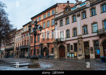 LVIV, UKRAINE: Regnerisches Wetter auf dem Marktplatz der Stadt mit Lampfosten und gepflasterten Straßen. Die Altstadt von Lemberg ist Teil des UNESCO-Weltkulturerbes Stockfoto