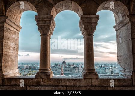 Panoramablick auf Budapest durch die Fenster der Fischerbastei bei Sonnenaufgang im Winter Stockfoto
