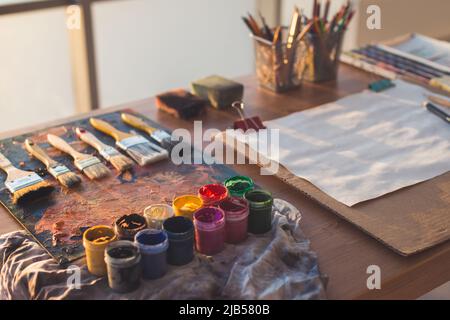 Arbeitsplatz des Malers. Palette mit Pinselstrichen und Pinsel. Bunte Gouache, Buntstifte Sets. Stockfoto
