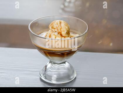 Vanilleeis mit Kaffeeexpresso auf einem Kaffeetisch Stockfoto
