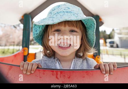 Umea, Norrland Schweden - 20. Mai 2022: Glückliches und niedliches Mädchen in Sonnenhut Stockfoto