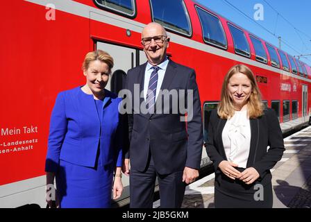 03. Juni 2022, Brandenburg, Potsdam: Franziska Giffey (l.), Regierender Bürgermeister von Berlin, Dietmar Woidke (beide SPD), Ministerpräsident von Brandenburg, und Daniela Kluckert (r), Parlamentarische Staatssekretärin bei der Bundesministerin für digitale Angelegenheiten und Verkehr, stehen vor dem Start des "Berlin-Brandenburg Rail Summit" am Bahnhof Potsdam-Sanssouci nebeneinander. Im Hintergrund fährt der Regionalzug nach Brandenburg (Havel), auf dem der Regierende Bürgermeister angekommen war. An dem anschließenden Treffen im Kaiserbahnhof nahm auch Daniela Kluckert, Parlamentarische Staatssekretarin, Teil Stockfoto