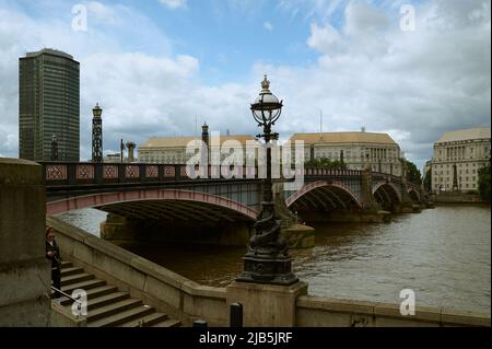 LondonUK - 29. Mai 2022: Blick über die braune / farbige Themse London und die Lambeth-Brücke und den millbank-Turm an sonnigen Tagen mit Wolken Stockfoto