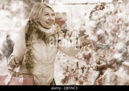 Frau bereitet sich auf Weihnachten vor und wählt Dekorationen für ihr Haus Stockfoto