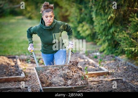 Bild einer müden Frau, die im Garten mit Werkzeugen arbeitet Stockfoto