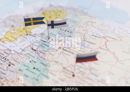 Finnland und Schweden und russische Flaggen auf der Europakarte. NATO-Flagge im Hintergrund Stockfoto