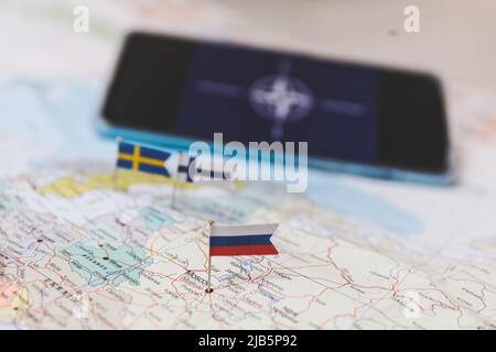 Finnland und Schweden und russische Flaggen auf der Europakarte. NATO-Flagge im Hintergrund Stockfoto