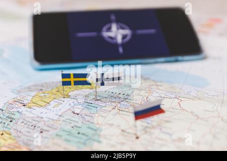 Finnland und Schweden und russische Flaggen auf der Europakarte. NATO-Flagge im Hintergrund Stockfoto