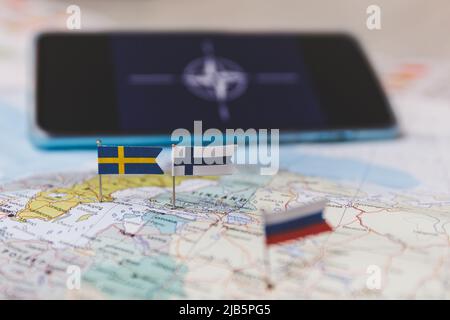 Finnland und Schweden und russische Flaggen auf der Europakarte. NATO-Flagge im Hintergrund Stockfoto