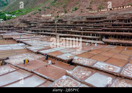 Qamdo. 26.. Mai 2022. Luftaufnahme vom 26. Mai 2022 zeigt Dorfbewohner, die in den Salzpfannen der Gemeinde Naxi im Bezirk Mangkam, Qamdo, südwestlich der Autonomen Region Tibet, arbeiten. Die Bewohner des Mangkam County folgen einer traditionellen Salzgewinnungsmethode, indem sie Solen aus Salzminen und Teichen sammeln und in der Sonne verdampfen, bis sie kristallisieren. Quelle: Zhou Dixiao/Xinhua/Alamy Live News Stockfoto