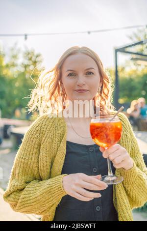 Schöne europäische 30s Mädchen Spaß im Café und trinken Obst-Cocktails mit Vergnügen, Outfit chillen im Restaurant am Wochenende Stockfoto