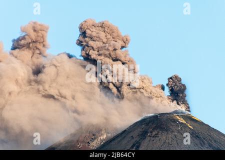 Riesige Wolken vulkanischer Asche, die aus dem südöstlichen Krater des Ätna, Sizilien, Italien, strömen. Anfang Mai 2022 wurde in diesem Krater eine neue Spalte eröffnet, die seitdem kontinuierlich aktiv ist. Der Ätna (3357m) ist einer der aktivsten Vulkane der Welt und der höchste in Europa Stockfoto