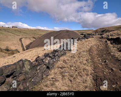 Das ehemalige Floating Light Pub am Horizont über einem Standedge Tunnel-Ablagehaufen neben dem Standedge Trail, Diggle. Stockfoto