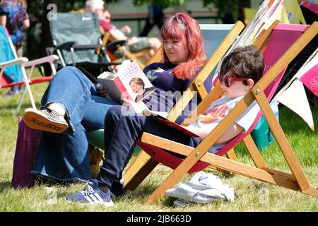 Hay Festival, Hay on Wye, Wales, Großbritannien – Freitag, 3.. Juni 2022 – Besucher von Hay können zwischen den Veranstaltungen beim ersten in Person Hay Festival seit 2019 – das Hay Festival findet bis Sonntag, den 5.. Juni 2022 statt – auf dem Rasen des Festivals lesen und entspannen. Foto Steven May / Alamy Live News Stockfoto