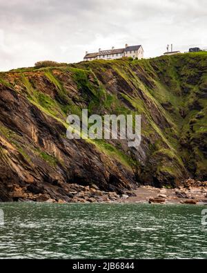 Ehemalige Küstenschutzhütten über Klippen mit Blick auf die Hele Bay in der Nähe von Ilfracombe, Devon, Großbritannien. Stockfoto