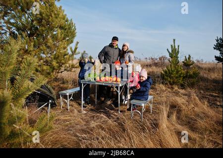 Fröhliche große Familie bei einem Picknick. Im Urlaub mit Obst im Freien. Stockfoto