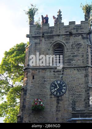 Die Garland wird am Höhepunkt der alten Castleton Garland Ceremony 2022 auf den Turm der St. Edmunds Church gehisst Stockfoto