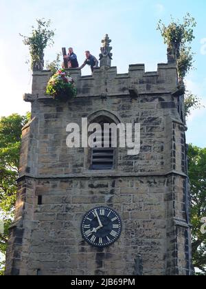 Die Garland wird am Höhepunkt der alten Castleton Garland Ceremony 2022 auf den Turm der St. Edmunds Church gehisst Stockfoto