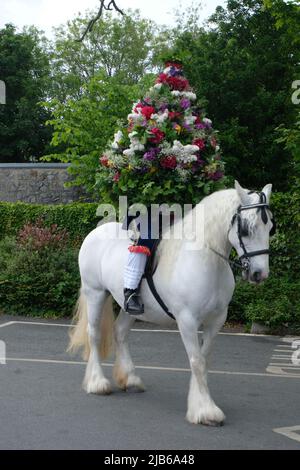 Porträt des Castleton Garland King, der während der alten Castleton Garland Ceremony 2022 eine Kranz aus Blumen zu Pferd trägt Stockfoto