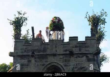 Die Garland befindet sich auf einer Spitze des Turms der St. Edmunds Church am Höhepunkt der alten Castleton Garland Ceremony 2022 Stockfoto