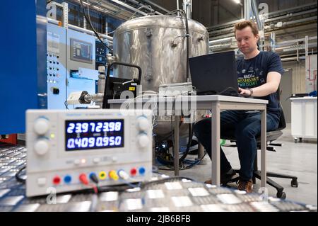 Freiberg, Deutschland. 03.. Juni 2022. Jan Böcker, wissenschaftlicher Mitarbeiter, sitzt am Rande einer Pressekonferenz zur Nacht der Wissenschaft und Industrie vor einem Plasmanitriersystem am Zentrum für effiziente Hochtemperatur-Materialumwandlung der TU Bergakademie Freiberg. Plasmanitrieren verbessert die Eigenschaften von Komponenten. Die Nacht der Wissenschaft und Wirtschaft findet am 18. Juni 2022 unter dem Motto „Sustain. Research. Live. Do Business“ statt. Quelle: Sebastian Kahnert/dpa/ZB/dpa/Alamy Live News Stockfoto
