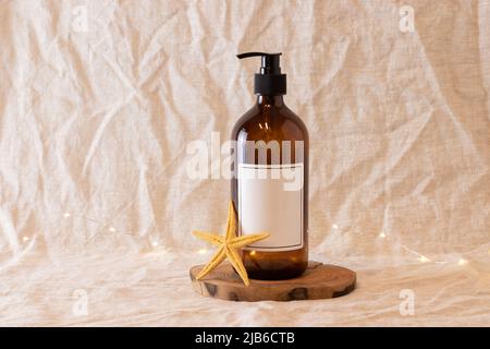 Leere bernsteinfarbene Glasseife oder Shampoo-Flasche auf isoliertem Hintergrund. Hautpflege oder Haarkonzept mit Naturkosmetik. Stockfoto