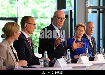 03. Juni 2022, Brandenburg, Potsdam: Dietmar Woidke (M, SPD), Ministerpräsident von Brandenburg, spricht im Rahmen einer Pressekonferenz nach dem "Berlin-Brandenburgischen Eisenbahngipfel" zusammen mit der Senatspressebeauftragten Lisa, Frerichs, Regierungssprecherin der Senatskanzlei (l-r), Jens Bergmann, Mitglied des Vorstands für Infrastrukturplanung DB-Netz AG, Franziska Giffey (SPD), Regierende Bürgermeisterin von Berlin, Und Alexander Kaczmarek, Konzernbeauftragter der Deutschen Bahn für die Region. Im Hintergrund ist ein restaurierter preußischer Schnellzug aus dem Jahr 1912 zu sehen. Über die weitere Deve wurden Gespräche geführt Stockfoto