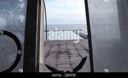 Blick auf Marina Asowsee Mariupol Ukraine aus dem Gebäude mit kaputten Fenstern Stockfoto