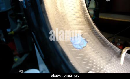 Reparatur-Service für Reifen des Autos von kleinen Punktion. Nahaufnahme der beschädigten Stelle mit dem Leim für den Putz. Stockfoto